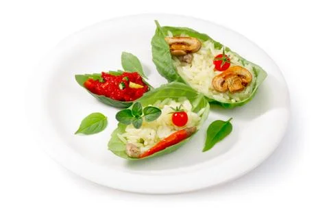 Boiled rice (risotto) served into basil leaves Stock Photos