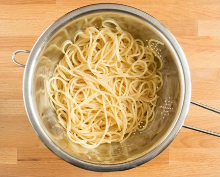 Boiled spaghetti in a colander without spices. Draining Stock Photos