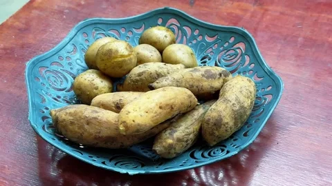 Boiled sweet potatoes served on a decorative plate on a wooden table Stock Footage 340050069
