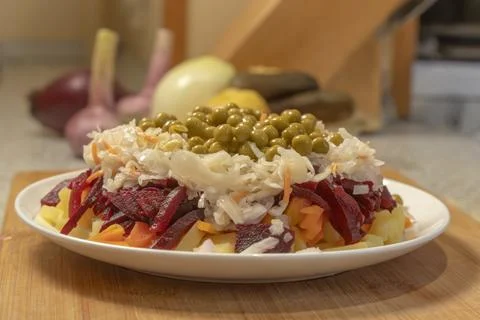 Boiled vegetable salad - beets, potatoes and carrots, green peas, onions, f.. Foto stock
