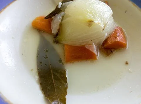 Boiled vegetables on a plate of broth . Stock Photos