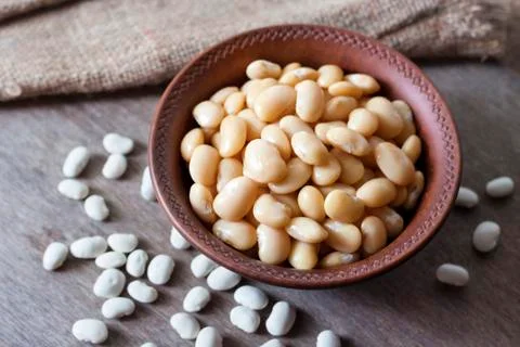 Boiled white kidney beans in a rustic bowl Stock Photos