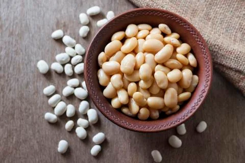 Boiled white kidney beans in a rustic bowl Stock Photos
