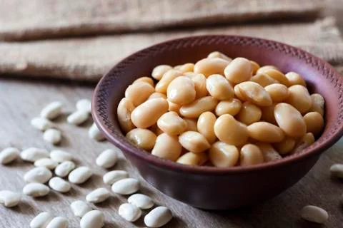 Boiled white kidney beans in a rustic bowl Stock Photos