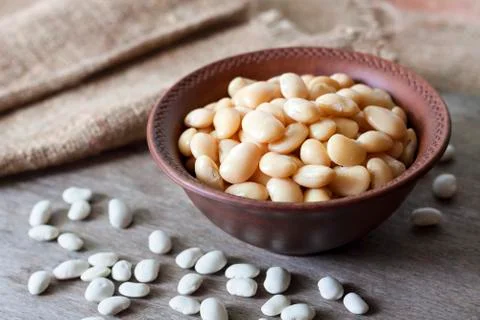 Boiled white kidney beans in a rustic bowl Stock Photos