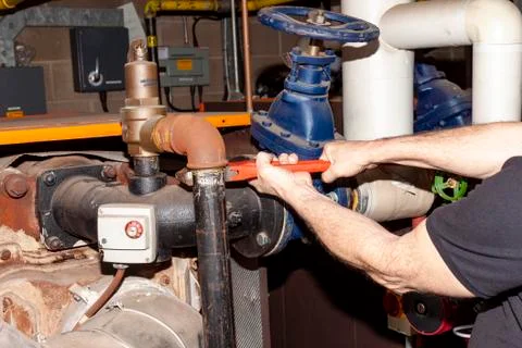 Boiler engineer removing a pipe from a safety valve Stock Photos