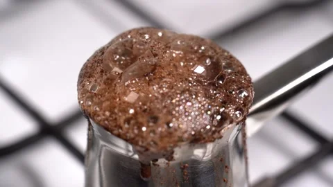 Boiling and overflowing coffee while preparation in turkish coffee pot Stock Footage 145265494