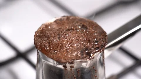 Boiling and overflowing coffee while preparation in turkish coffee pot Stock Footage 148976572