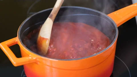 Boiling beans in thick hot tomato sauce, close up Stock Footage 205073337