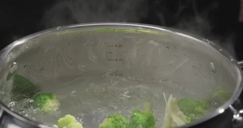 Boiling broccoli in a pot. Fresh broccoli falling into pot with boiling water Stock Footage 250770904