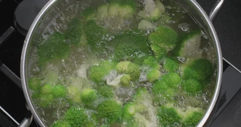 Boiling broccoli in a pot on induction stove. Slow motion Stock Footage 249981612