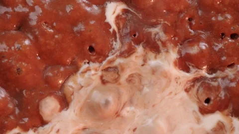 Boiling caramel. Macro shot of bubbles in boiling thick dark yellow liquid Stock Footage 153996253