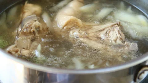 Boiling chicken frame in pot to make soup, in door  Chiangmai  Thailand Stock Footage 134440969