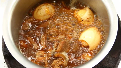 Boiling chopped pork and eggs with sauce in pot, in door  Chiangmai  Thailand Stock Footage 132622699