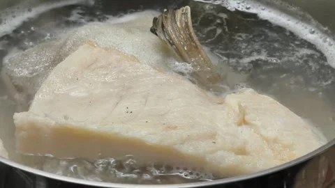 Boiling cod fish in water in iron pot 스톡 동영상 334188072