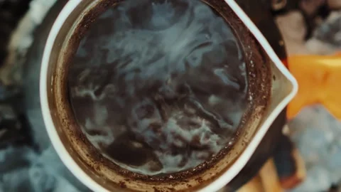 Boiling coffee on a fire in cezve coffee pot close-up vertical Stock Footage 256992397