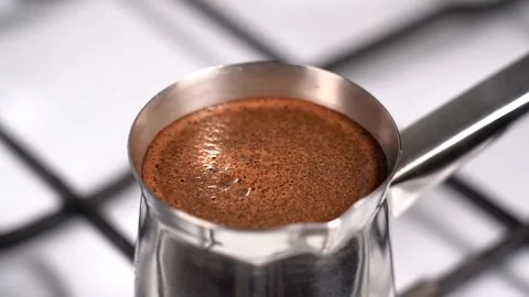 Boiling coffee while preparation in turkish coffee pot Stock Footage 148976563