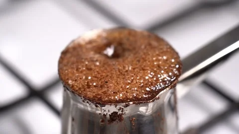 Boiling coffee while preparation in turkish coffee pot Stock Footage 148976612