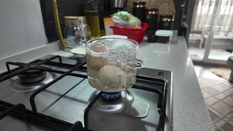Boiling Eggs in Glass Pot on Kitchen Gas Stove Wide Shot Stock Footage 331564515