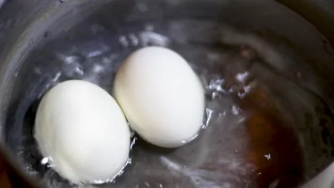Boiling eggs in pot for healthy breakfast preparation Stock Footage 331561453
