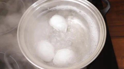 Boiling eggs in a saucepan, kitchen cooking, stove-top meal preparation, br.. Stock Footage 268220716