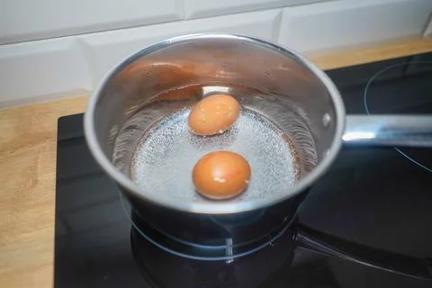 Boiling eggs in the silver pot. Hard boiled eggs. Stock Photos