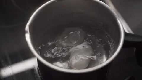 Boiling eggs in small pot on electric stove at home. Fresh white chicken eggs Video stock 316913248