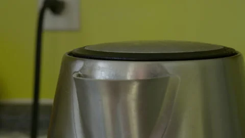 Boiling electric kettle in yellow kitchen with electric wall plug 스톡 동영상 275302394
