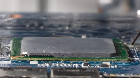 Boiling flux paste around the grid array microchip. Desoldering a microprocessor Stock Footage 92438988