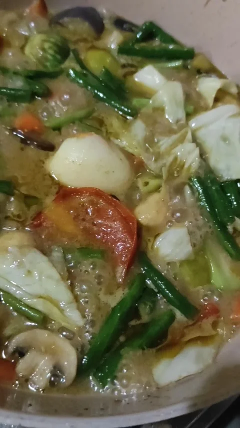 Boiling green curry inside pink pan Stock Footage 256578037