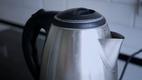 Boiling grey electric kettle boiling with steam emitted from spout. Shallow d Stock Footage 119820786