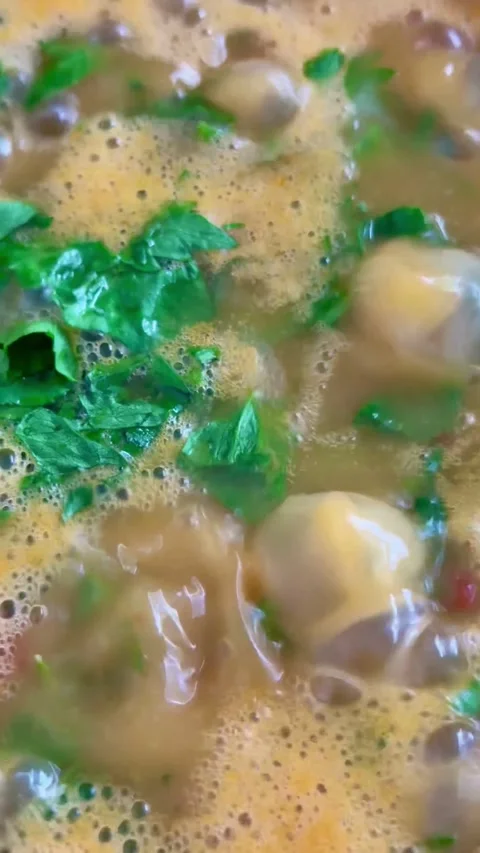 Boiling healthy chickpea stew with fresh green herbs cooking Stock Footage 331973766
