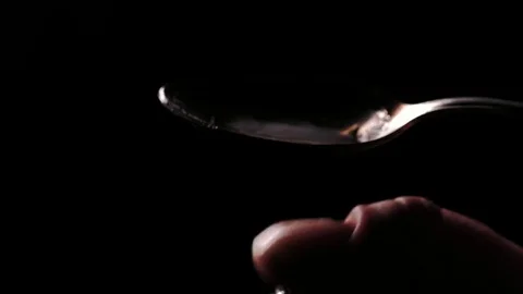 Boiling heroin in a spoon. Low key shot. Video stock 82877921