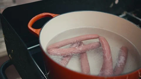 Boiling hot dogs outside in orange pot Stock Footage 280331002