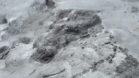 Boiling hot water cascading down a grey rock face from an erupting, geothermal g Stock Footage 171688931