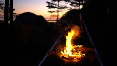 A boiling kettle on the campfire at the night Stock-Footage 133972715