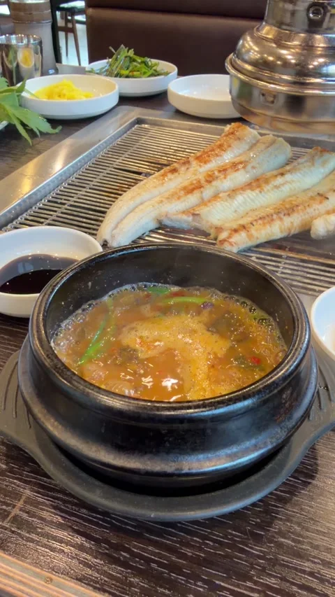 Boiling Korean Stew in Stone Pot with Grilled Eel Stockbeeldmateriaal 337567006
