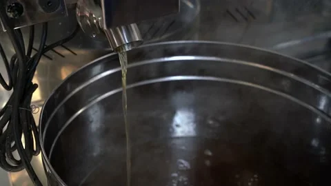 Boiling maple syrup pouring from evaporator pan into stainless steel container. 스톡 동영상 237785838
