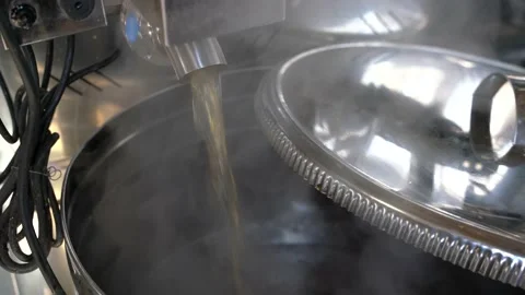 Boiling maple syrup pouring out of evaporator into stainless steel container. 스톡 동영상 237770259