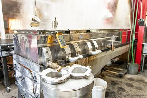 Boiling maple syrup sap boiling pans with steam Foto stock