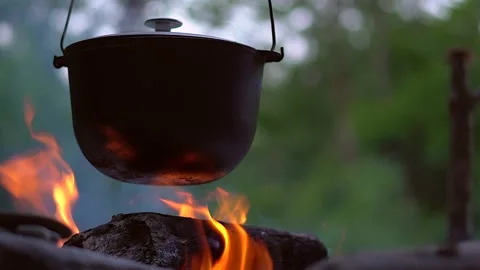 A boiling metal pot on a fire Stock Footage 136876451