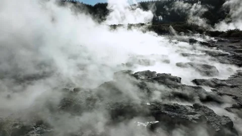 Boiling mud pools, Drone slowly flying over geothermal landscape. Trees, steam Stock Footage 307600101