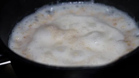 Boiling oat meal with milk Video stock 88171322