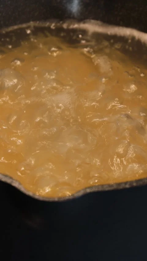 Boiling pasta in starchy bubbling water inside black pot on stove during cooking Stockbeeldmateriaal 314267112