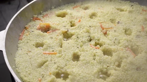 Boiling pilaf in cauldron. Boils rice with carrot and spice Stock Footage 114494472