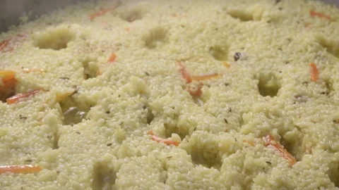 Boiling pilaf in cauldron. Boils rice with carrot and spice Stock Footage 114494543