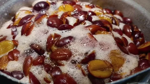 Boiling plum halves simmering in sugar syrup for homemade jam Stock Footage 344878361