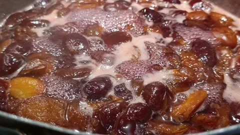Boiling plum halves simmering in sugar syrup for homemade jam Stock Footage 344878384