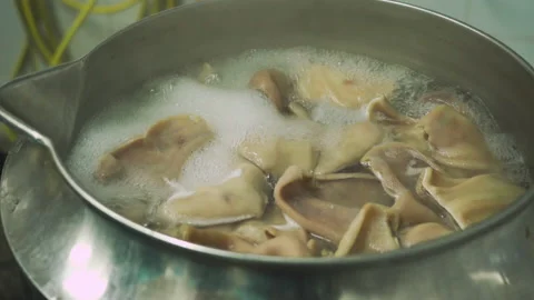 Boiling pork ears for use in making sausages in a meat factory. Part of sausage 库存影片 131858943