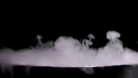 Boiling pot of smoke on black background Stock Footage 81863352